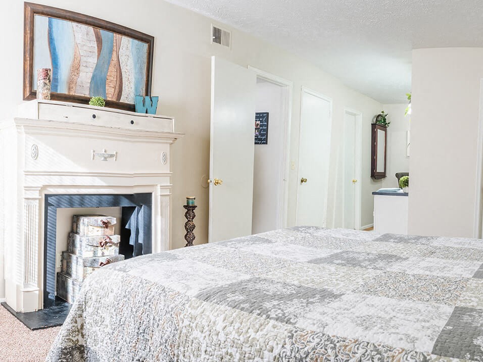 a bedroom with a large bed and a fireplace