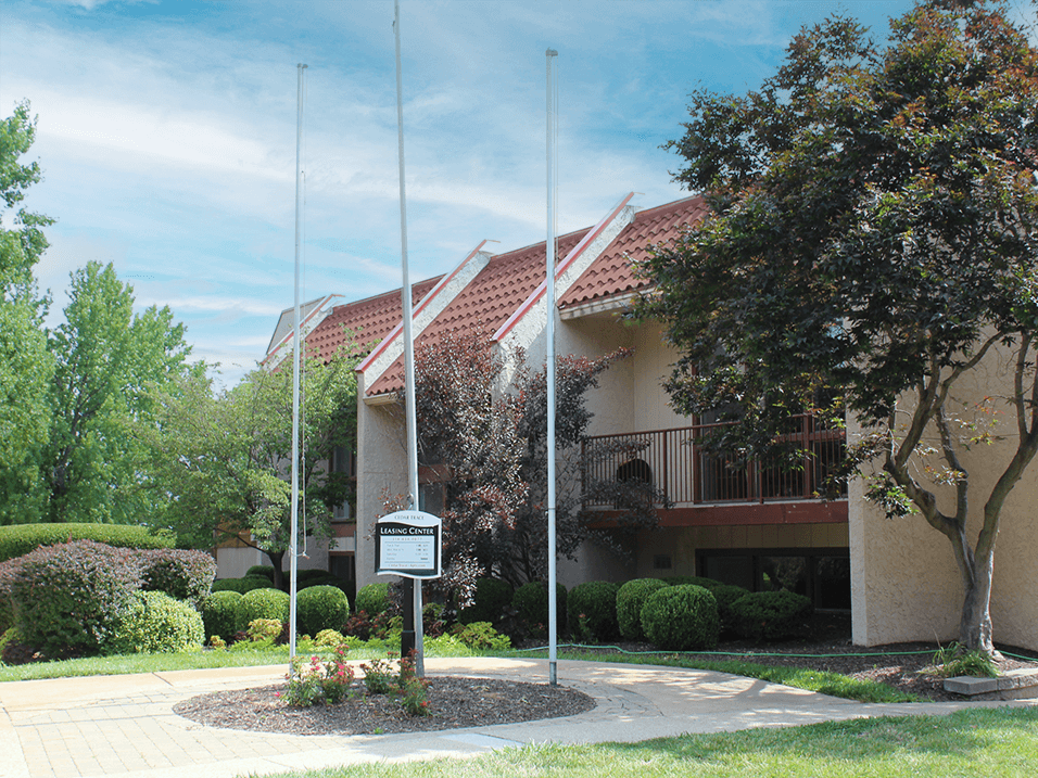 a building with two flag poles and a sign in front of it