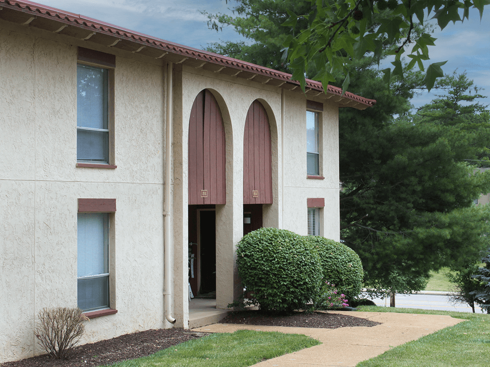 apartment building with three windows and a walkway in front of it