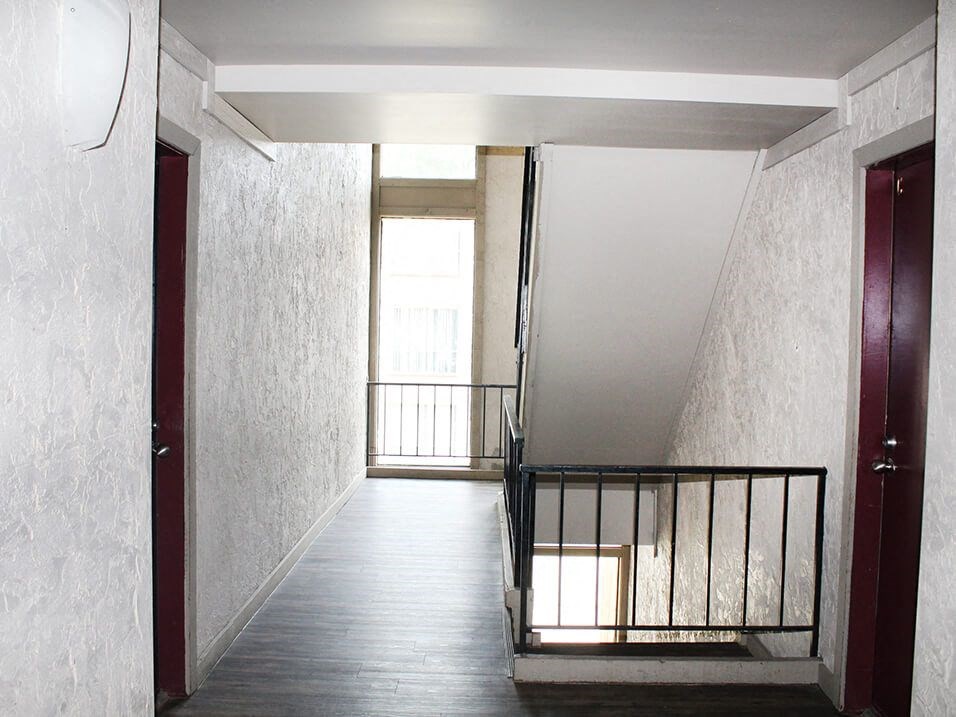 a view down a flight of stairs with a window on one side and a railing on the