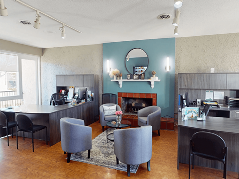 A living room with a grey couch and a fireplace.