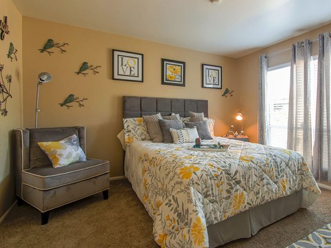A bedroom with a large bed and a bench.