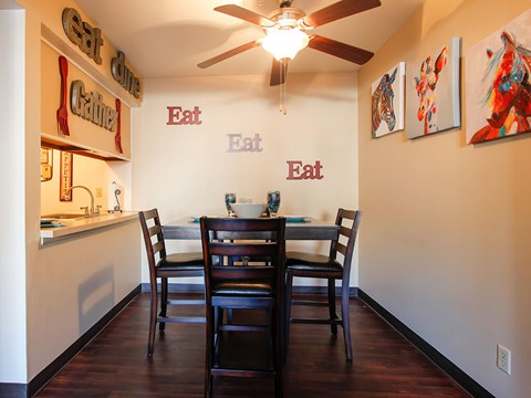 A dining room with a table and chairs.
