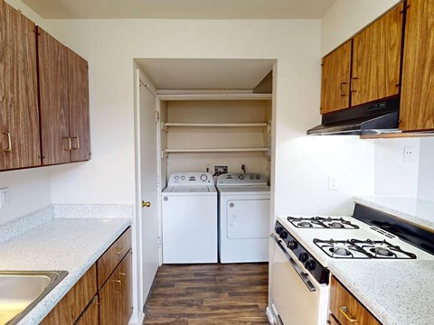 A kitchen with a white stove top oven and a white dishwasher.