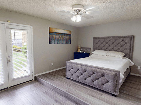 A bedroom with a large bed and a painting on the wall.