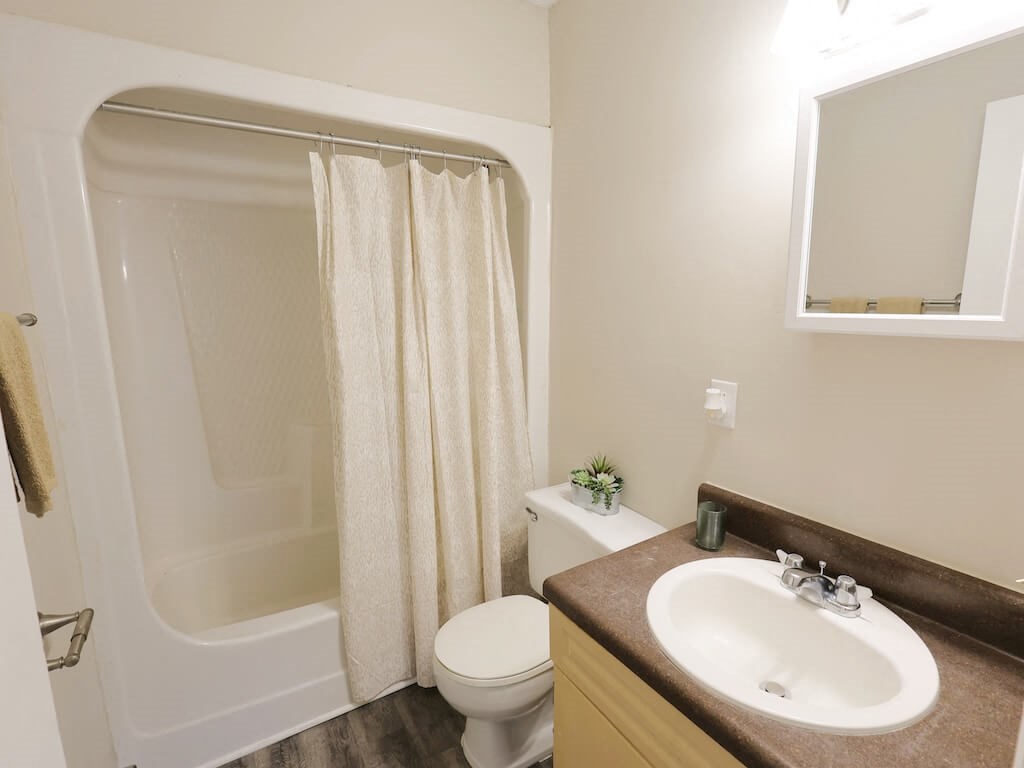 A bathroom with a toilet, sink, and shower.