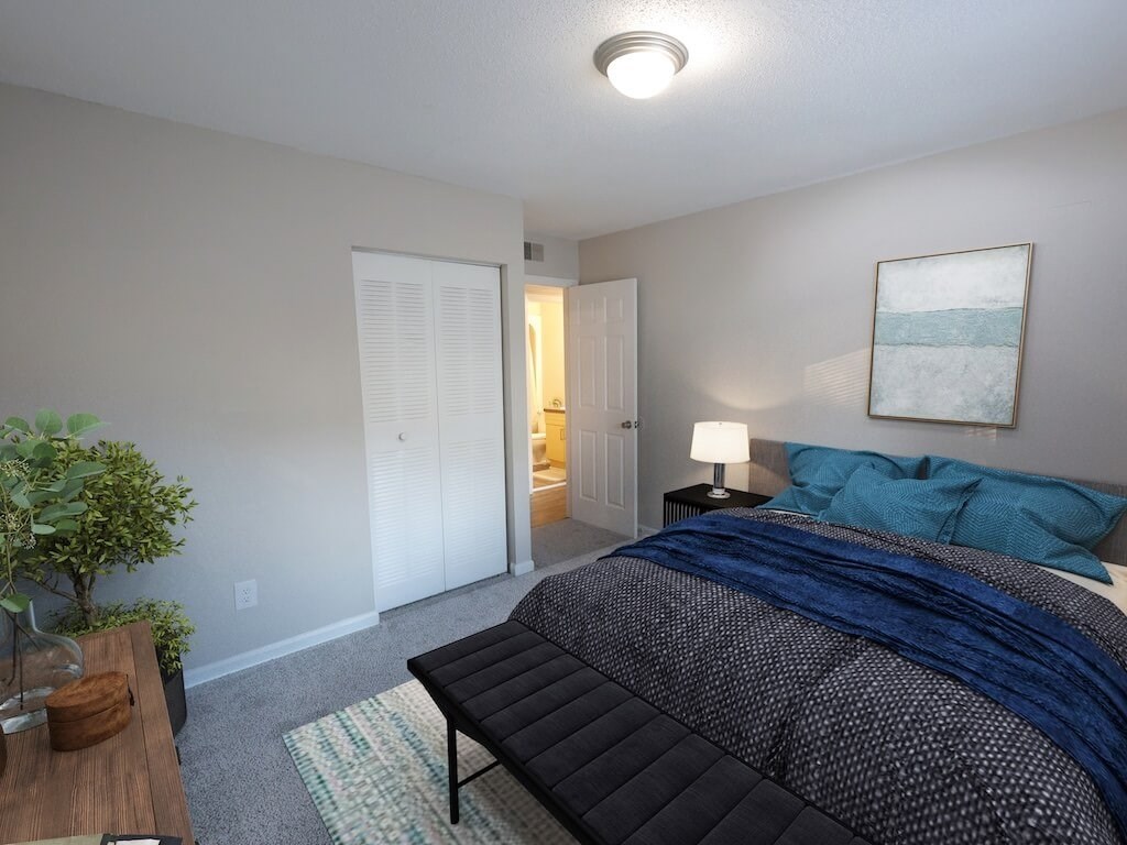 A bedroom with a bed, nightstand, and lamp.