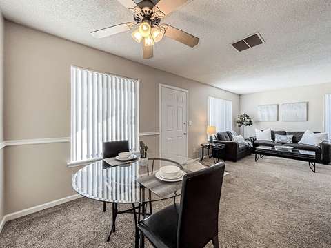 an open living room and dining room with a glass table