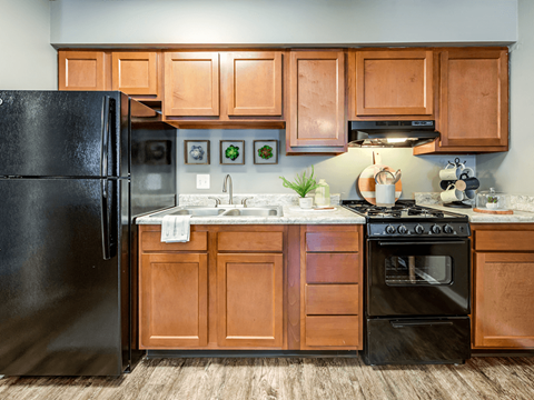 a kitchen with black appliances and wooden cabinets