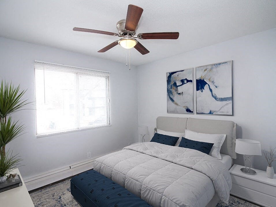 a bedroom with a bed and a ceiling fan