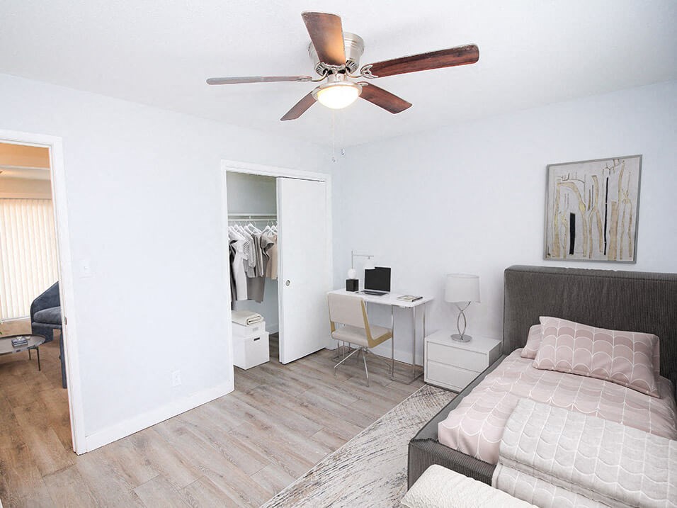 a bedroom with a ceiling fan and closet