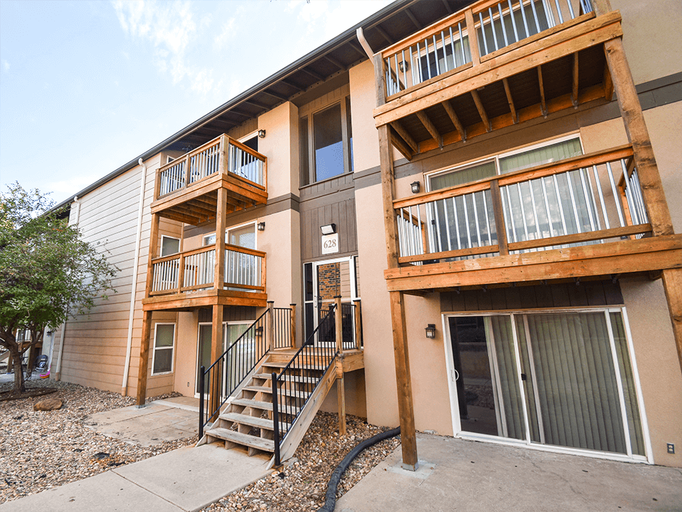an exterior view of an apartment building with stairs and balconies