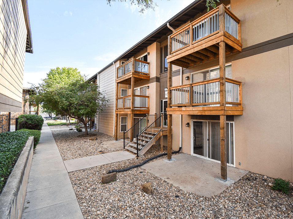 an exterior view of a building with balconies and a sidewalk