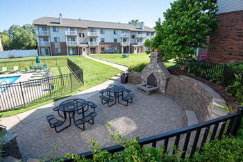 a backyard with a fire pit and picnic tables