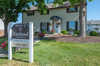 the eastland apartments leasing office sign in front of the office