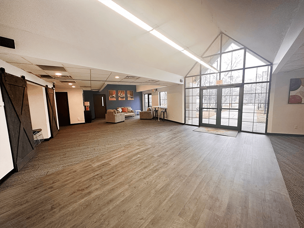 a large room with a wood style floor and a large window