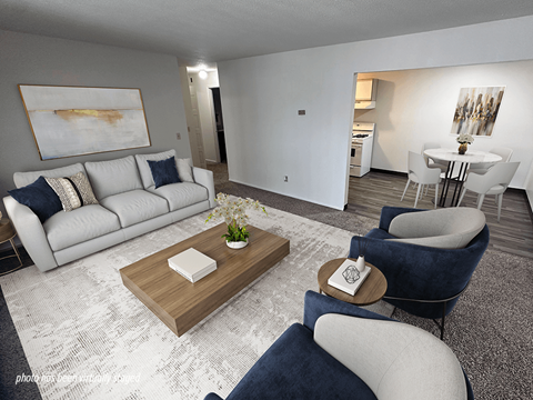 A modern living room with a white sofa, a grey armchair, and a wooden coffee table.