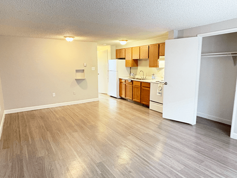 A kitchen area with wooden cabinets and a white refrigerator.