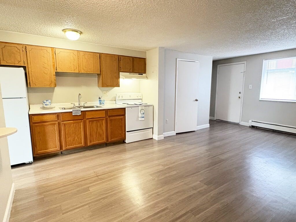 A kitchen with wooden cabinets and a white refrigerator.
