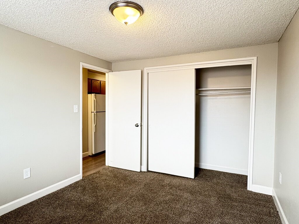 A room with a carpeted floor and a white ceiling with a light fixture.