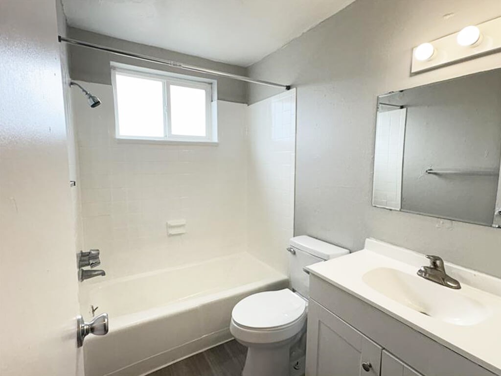 A white bathroom with a toilet, sink, and bathtub.