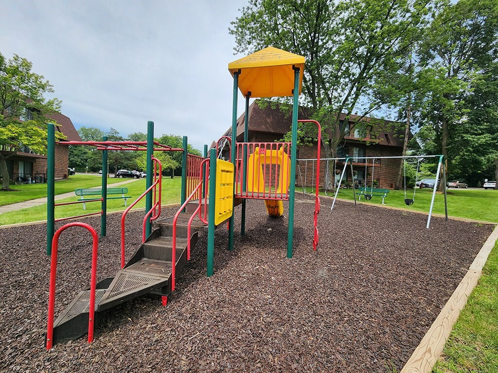 playground with a swing set at apartment