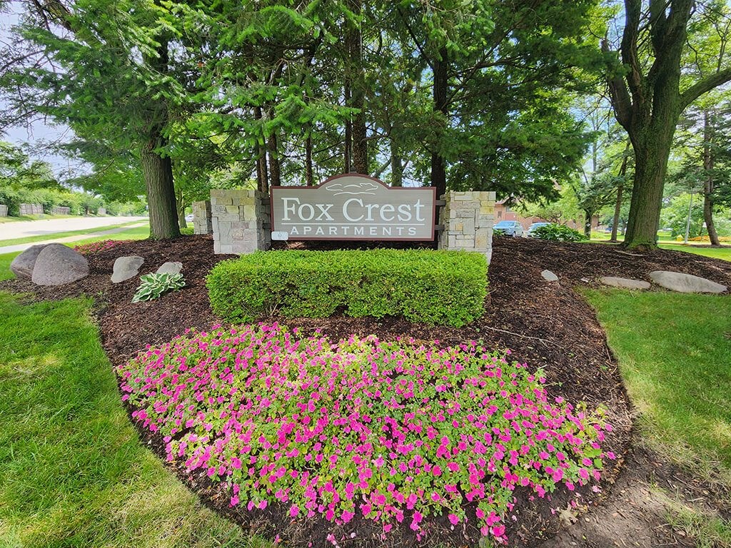sign for Fox Crest Apartment with flowers
