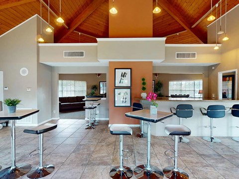 A modern bar area with stools and a counter.