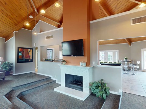 A living room with a fireplace and a television on the wall.