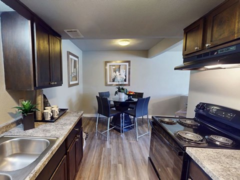 A kitchen with dark wood cabinets and a black stove top oven.