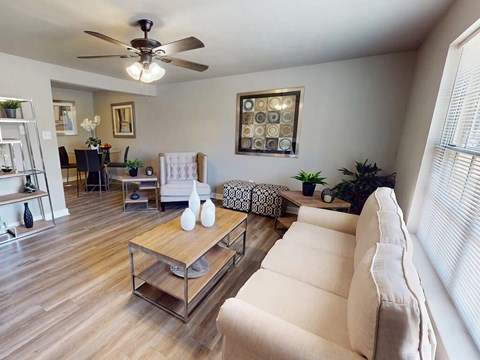 A living room with a white couch and a wooden coffee table.