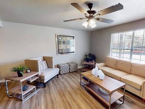 A living room with a white sofa, a wooden coffee table, and a ceiling fan.