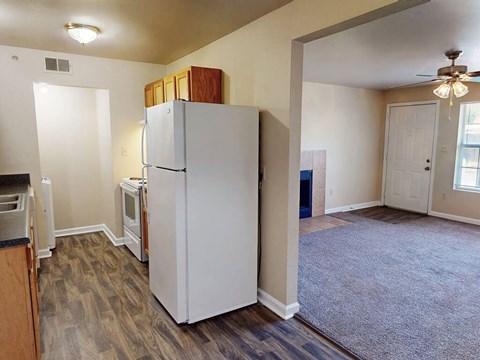 A white refrigerator in a room with a ceiling fan.