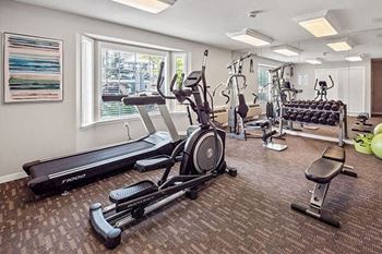 a gym with various exercise machines and a window