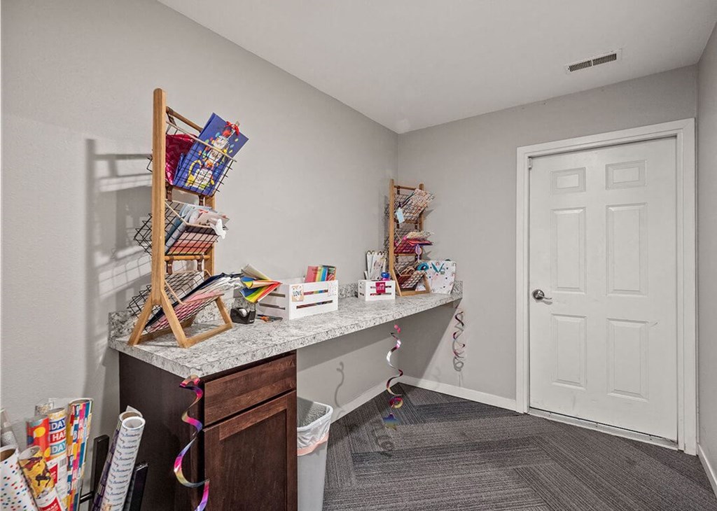 a room with a desk with gift wrapping materials and other items on it