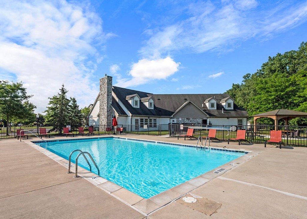 a swimming pool with a house in the background