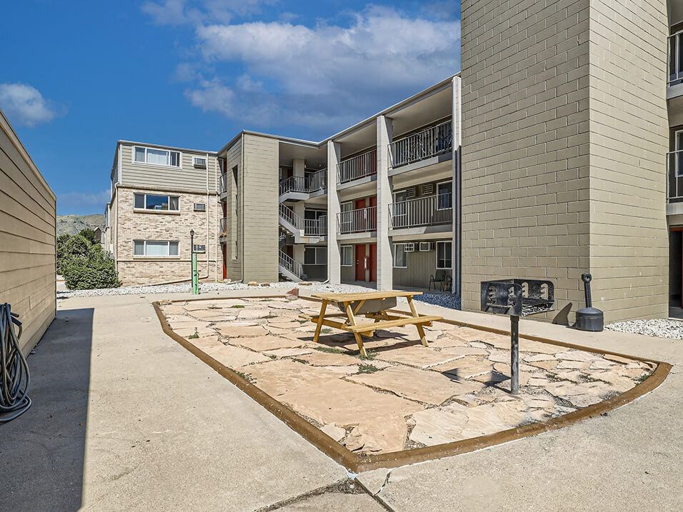 a picnic table in front of an apartment building