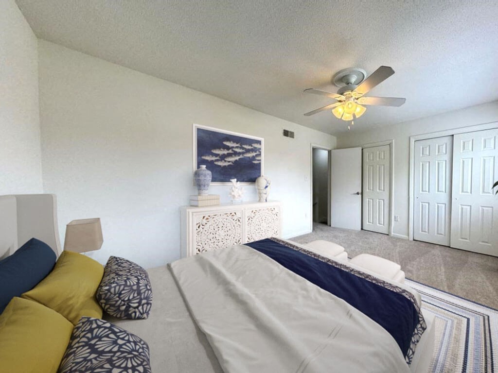 a bedroom with a bed and a ceiling fan