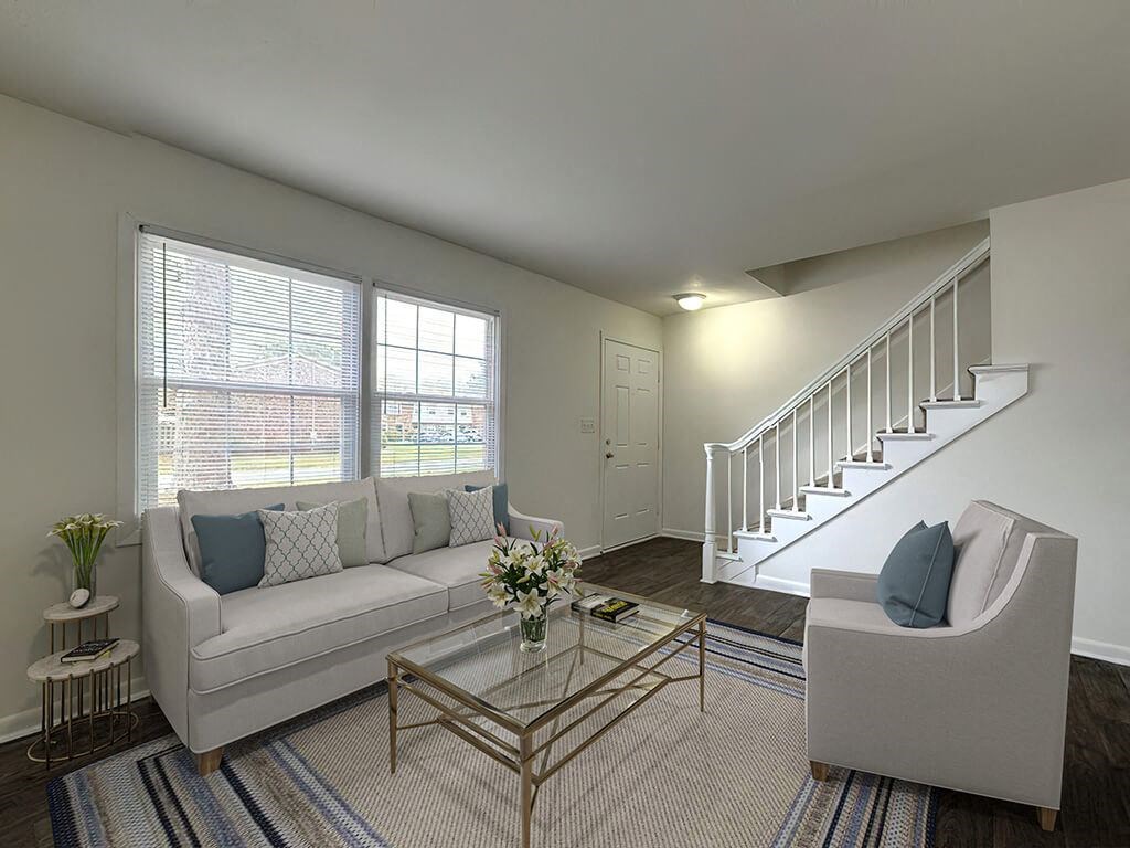 a living room with a white couch and a staircase