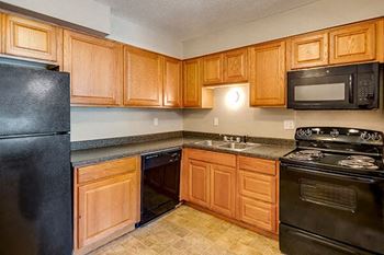 a kitchen with black appliances and wooden cabinets