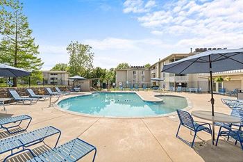 a large swimming pool with chairs and umbrellas