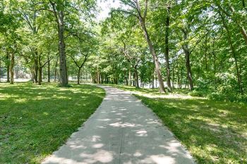 a path in a park with trees and grass