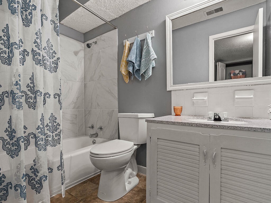 a bathroom with a shower and a toilet and a sink