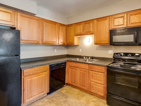 a kitchen with black appliances and wooden cabinets