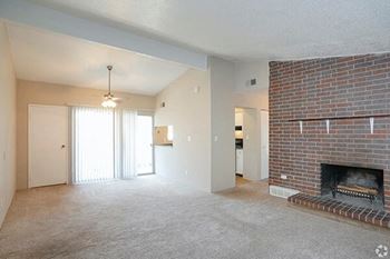 an empty living room with a brick fireplace