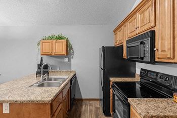 a kitchen with black appliances and granite counter tops