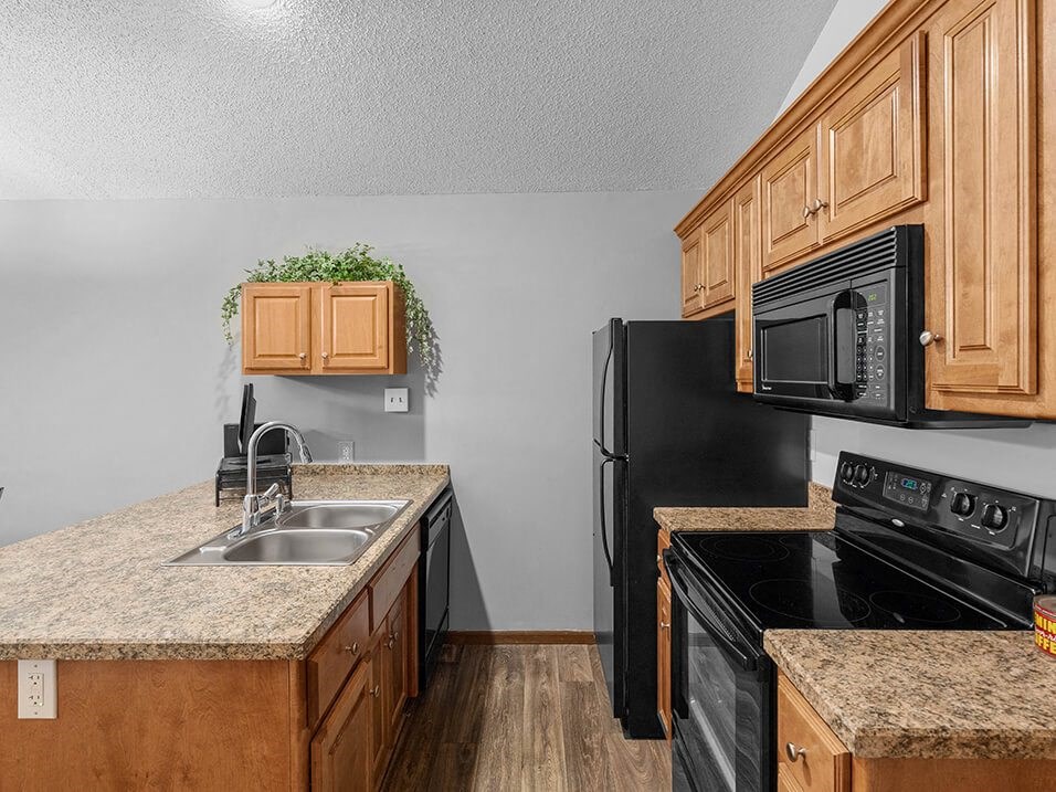 a kitchen with black appliances and granite counter tops