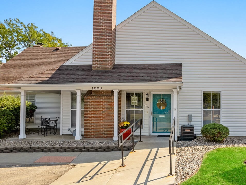 the front of a white house with glass doors