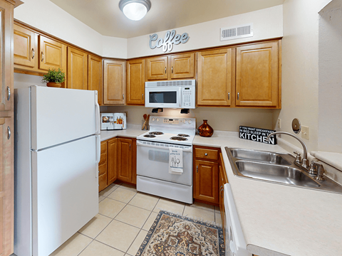 A kitchen with a white refrigerator and a white stove.