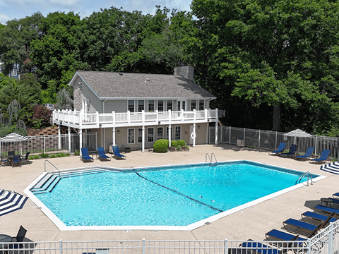 A pool with a house in the background.